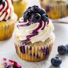 blueberry cupcakes with white frosting and fresh berries