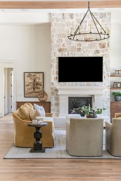 a living room filled with furniture and a flat screen tv mounted on the wall above a fireplace