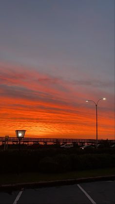 the sun is setting over an empty parking lot