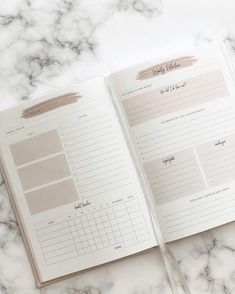 an open planner book sitting on top of a marble counter