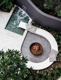 an aerial view of a patio with a fire pit in the center and plants around it