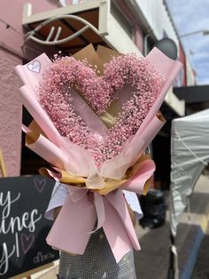 a bouquet of pink sprinkles in the shape of a heart is tied to a post