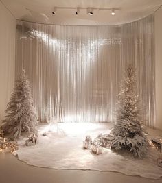 a room with white curtains and snow covered trees in the center, surrounded by christmas decorations