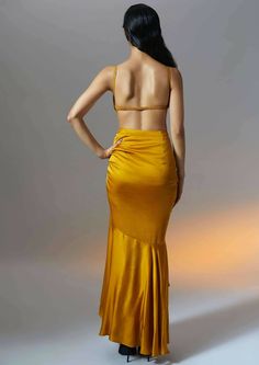 This marigold muse ruched skirt with layered ruffle hem is generously dipped in mustard gold hue. This skirt exudes summer sensuality as the tiers of softly draped satin flow with ease on the body. The playful adjustable drawstring details further accentuate the curves and truly celebrate femininity. Ruched Party Skirt, Satin Ruched Skirt For Night Out, Satin Skirt With Ruched Detail For Night Out, Ruched Satin Skirt For Night Out, Party Tiered Draped Skirt With Gathered Details, Gold Silk Bottoms For Party, Party Satin Ruched Skirt, Yellow Long Skirt For Evening, Chic Gold Maxi Skirt For Evening