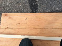 a person standing on top of a wooden bench with their feet propped up against it