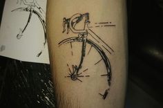 a close up of a person's arm with a bike tattoo on it