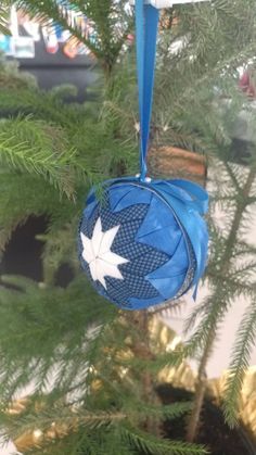 a blue ornament hanging from a christmas tree