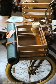 an old fashioned bicycle with wooden crates on the back and seat, as well as other antique bicycles