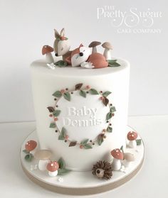 a white cake decorated with woodland animals and the words baby donuts written on it