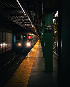 a subway train pulling into the station at night