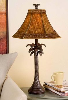 a lamp that is sitting on top of a table next to a cup and book