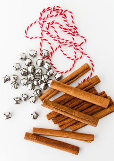 several pieces of wood, bells and twine on a white surface with red and white string