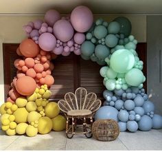 there are many balloons in front of the door and chair on the floor next to it