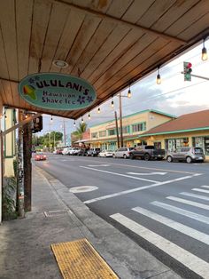 a street with cars parked on the side of it and a sign that says julian's shave shop