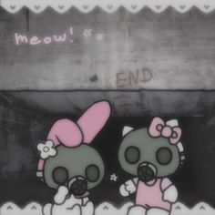 two hello kitty dolls standing next to each other in front of a graffiti covered wall