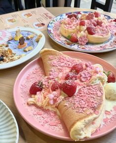 two plates with pastries and strawberries on them