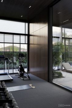 an exercise room with treadmills and windows