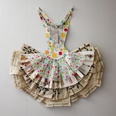 a dress made out of newspapers is hanging on the wall