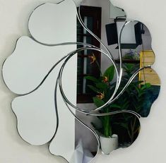 a mirror that is on the wall next to a potted plant