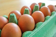 an egg carton filled with brown eggs on top of a wooden table