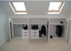 an attic bedroom with white closets and drawers