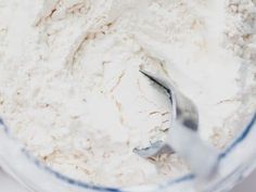 a spoon in a bowl filled with flour