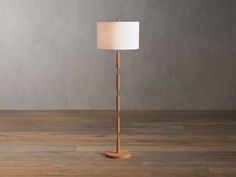 a wooden floor lamp with a white shade