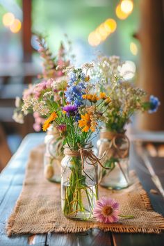 two mason jars filled with wildflowers sit on a burlocked placemat