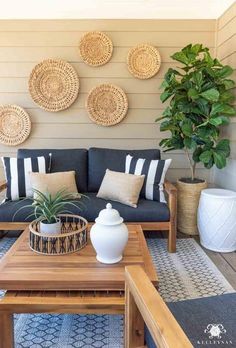 a living room with couches, tables and plants on the wall in front of it