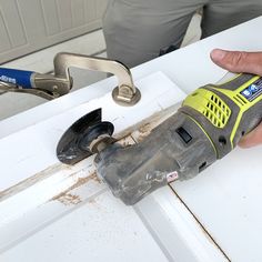 a man is using a drill to fix a window sealer on the outside of a door