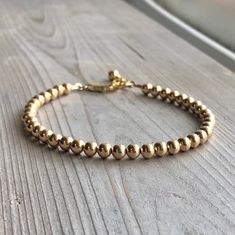 This classic style bracelet will quickly become your everyday go-to bracelet. All handmade and hand strung this bracelet is made with 4mm 14K Gold Filled beads and ends with a sturdy lobster clasp, including a 1" extension for your perfect fit.  It's a versatile bracelet that's perfect for special occasions and simple enough for everyday. Wear it to work or with your favourite jeans and T-shirt combo, it's adjustable dainty, elegant and perfect for stacking. D E T A I L S ➤ 14K Gold Filled ➤ Bea Gold Ball Bracelet, Original Jewelry Design, Bracelet Minimalist, Ball Bracelet, Stacked Bangles, Elegant Bracelet, Layered Bracelets, Birthday Gift For Her, Bracelet Stack