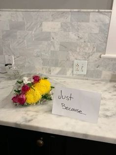 flowers are left on the kitchen counter next to a note