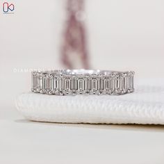 a diamond ring sitting on top of a white cloth