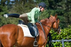 a woman riding on the back of a brown horse