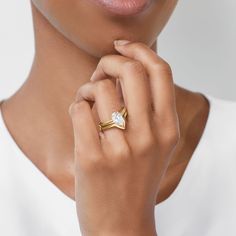 a close up of a person wearing a ring with a diamond on the middle finger