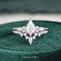 a diamond ring sitting on top of a green cloth