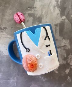 a coffee cup with a stethoscope on it next to a ball of yarn