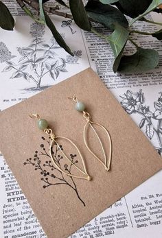 A delicate and elegant pair of handmade leaf earrings. Hand shaped from gold plated wire and lightly hammered to give them strength. Natural green gemstone beads have been set above the leaves  please note ** the shade of green beads may vary slightly from the photo due to their natural variation of colouring) Hung from gold plated French hooks The leaves measure approx 4cm and the whole earrings has a length of approximately 6cm Super lightweight and easy to wear.  They would make a lovely little gift All our orders are nealty giftwrapped and sent in ecofriendly packaging. A personalised note from the sender can be added to the order if you just let us know what your message is at the checkout    Visit us on Instagram www.instagram.com/lilbits.shop Green Beads, Hand Shapes, Handmade Gold, Green Gemstones, Wire Earrings, Green Bead, Leaf Earrings, Spacer Beads, Handmade Earrings