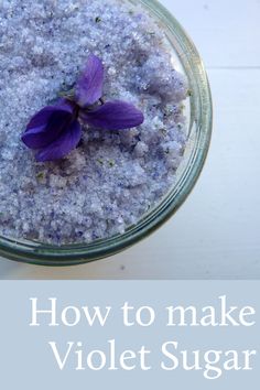 a bowl filled with lavender sugar and a purple flower sitting on top of it's side