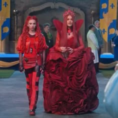 two women in red dresses walking down the street