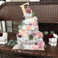 a multi layer cake with flowers on the top and two small vases next to it