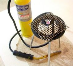 a grill with a bottle of mustard next to it on a towel and a blow dryer