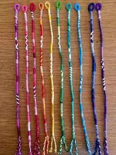 several different colored bracelets sitting on top of a wooden table