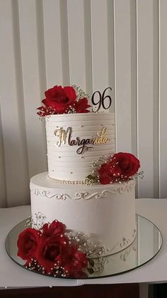 a white cake with red flowers on top and the number sixty written on the side