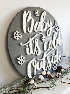 a wooden sign that says baby it's cold outside on top of a mantle