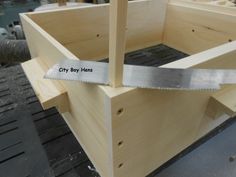 a wooden box with a saw in it and the words city boys written on it