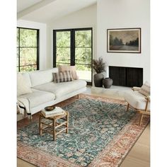 a living room filled with furniture and a large rug on top of a hard wood floor