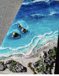 an image of a beach scene with rocks and water on the sand in front of it