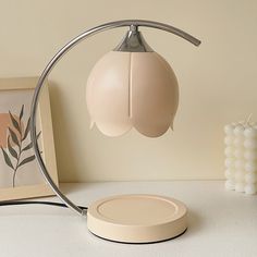 a table lamp sitting on top of a white counter next to a framed photograph and vase