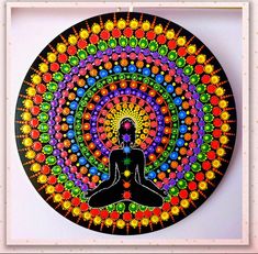 a painting of a person sitting in the middle of a rainbow colored circle with an intricate design on it